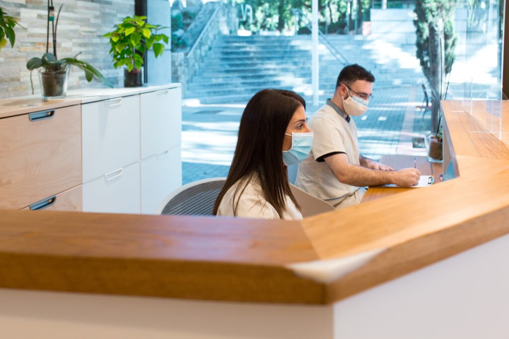 Colleagues in masks working at reception desk