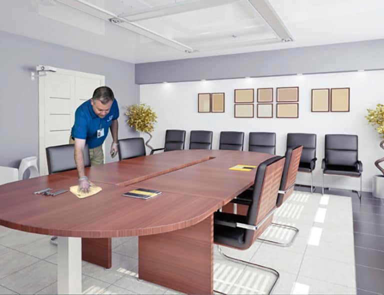 JAN-PRO Cleaning & Disinfecting employee cleaning a conference room