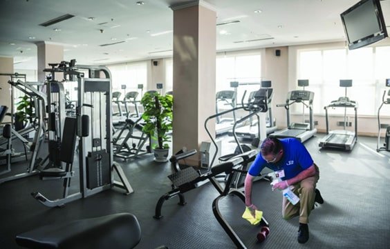 A JAN-PRO Cleaning & Disinfecting employee cleaning a fitness studio