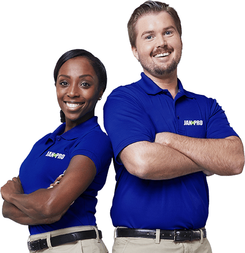 an African-American woman and Caucasian man JAN-PRO Cleaning & Disinfecting attire smiling with their arms folded