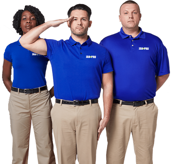 Three JAN-PRO Cleaning & Disinfecting employees posing with one in the middle saluting