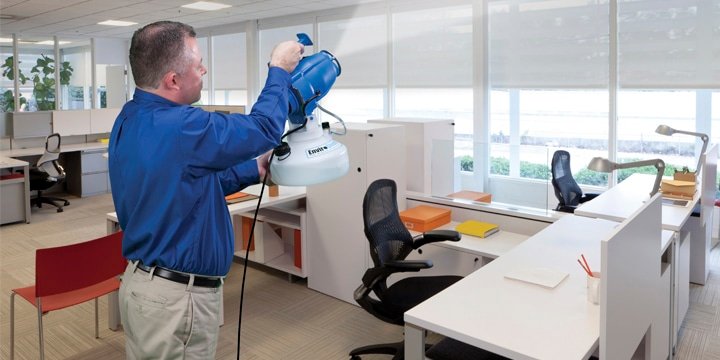 a commercial cleaning professional using cleaning products in an office.