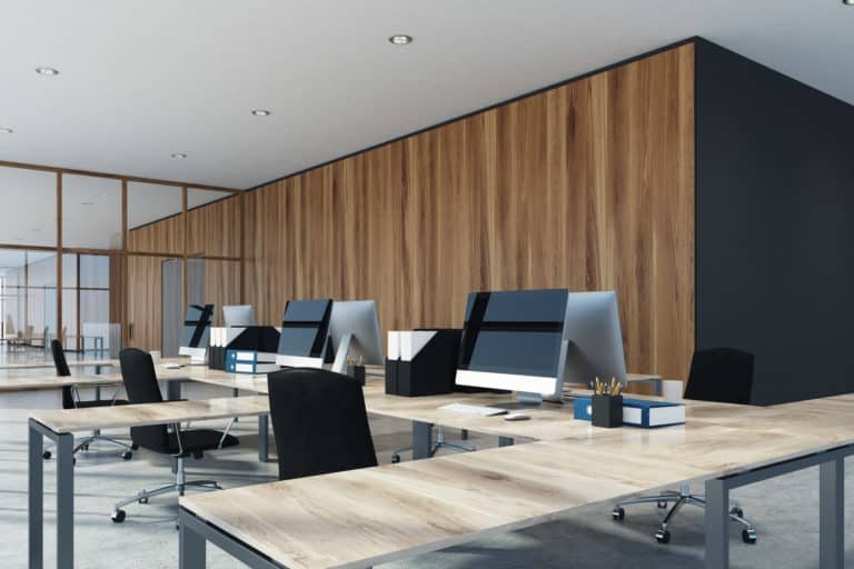 Environmental style open space office interior with a concrete floor, wooden walls and computer tables. 3d rendering mock up