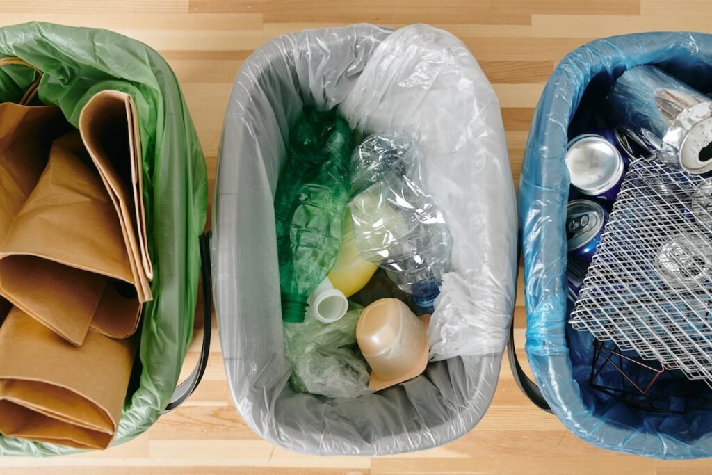 View of three containers with recyclable garbage on table