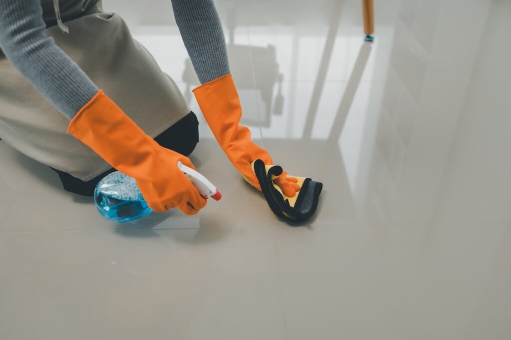 Person cleaning a tiled floor.