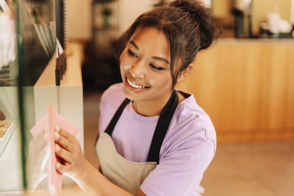 Image of a commercial cleaning professional wiping down a glass panel