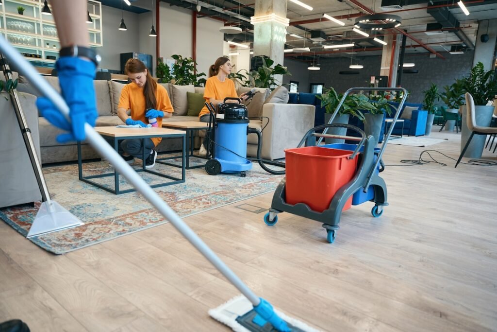 Cleaning a workspace, workers use a vacuum cleaner.