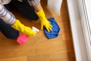 Image of a woman cleaning a wooden floor.