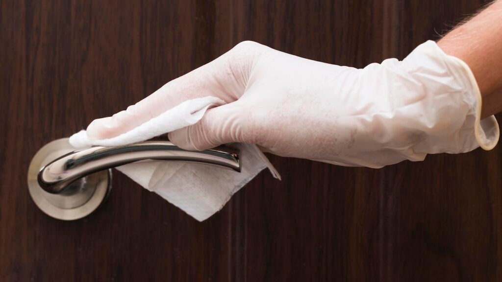 Wiping down a doorknob.