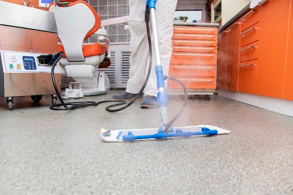Worker cleans the floor in the dental office.