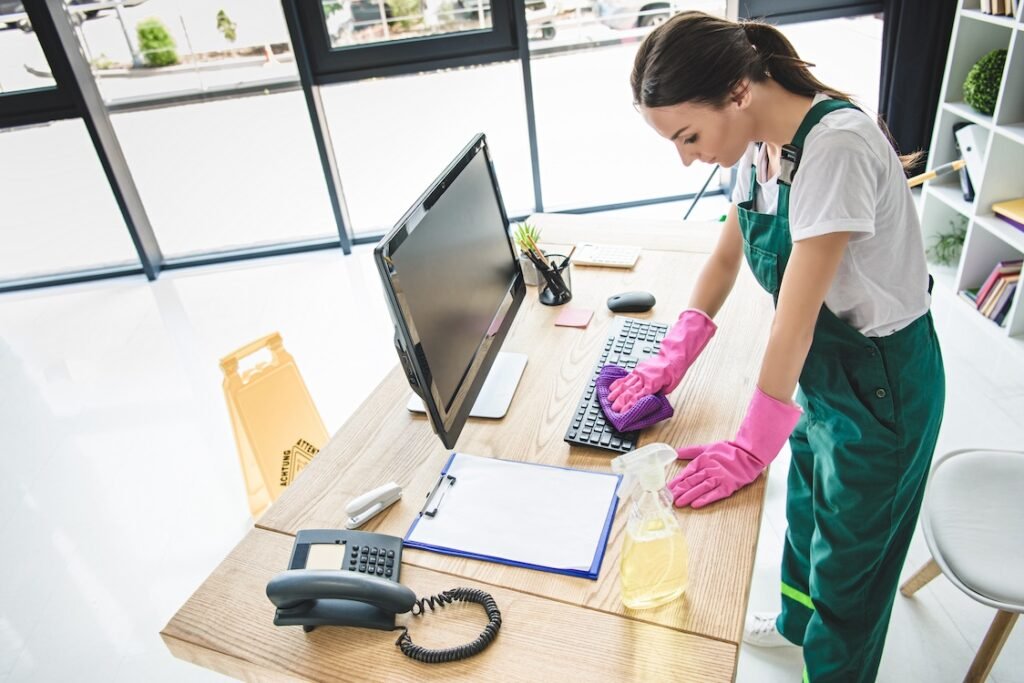 Commercial cleaning crew cleaning off a desk.