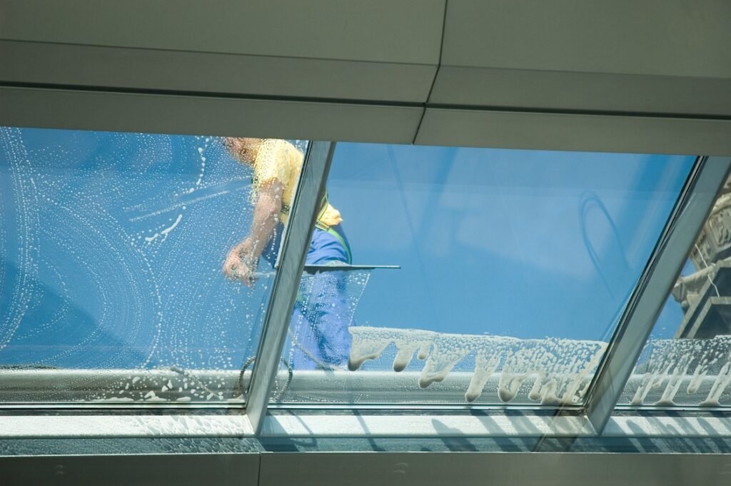 Cleaning wiping down windows on a ceiling.
