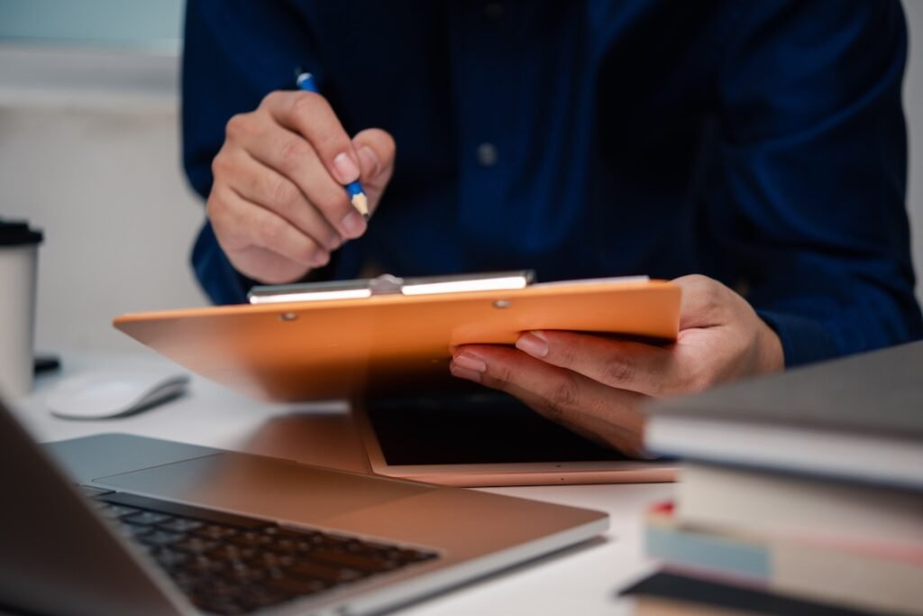 Man holding clipboard with checklist employee workplace is reviewing documents.